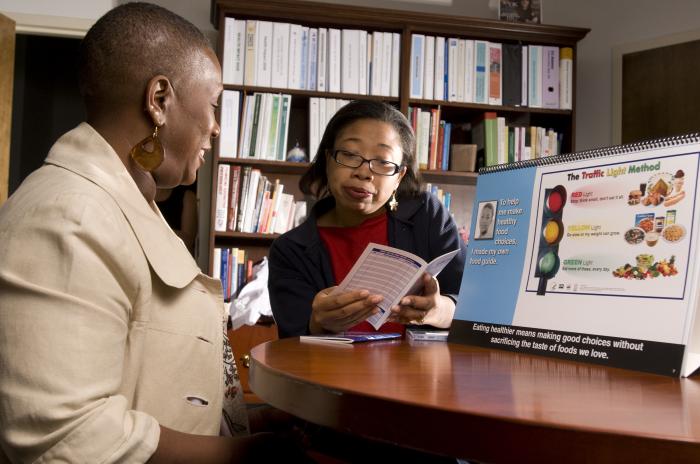 Photograph of a patient with diabetes talking to a community health worker about their condition.